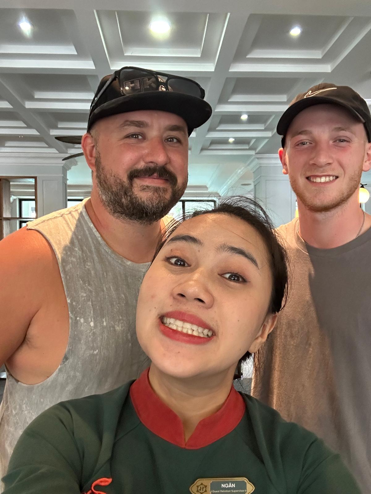 Smiling selfie with family and a new friend in a hotel lobby in Vietnam