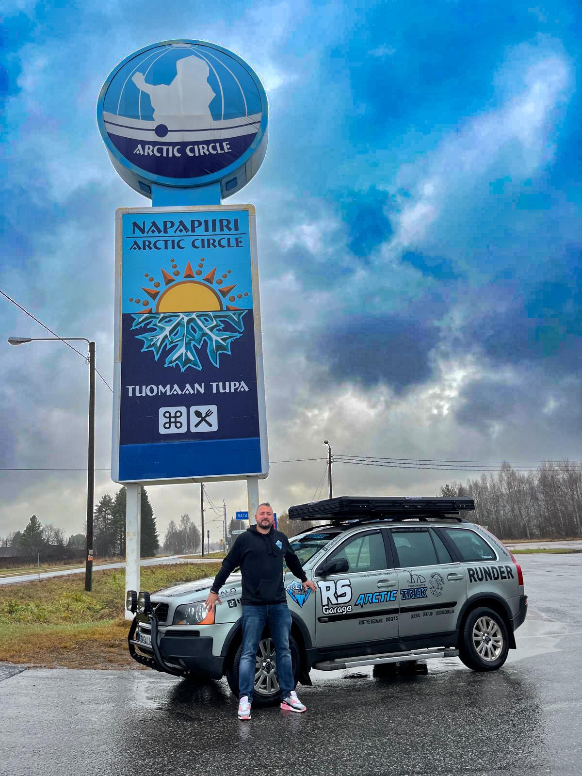The liveried Volvo XC90 parked beneath the Napapiiri Arctic Circle sign in Rovaniemi
