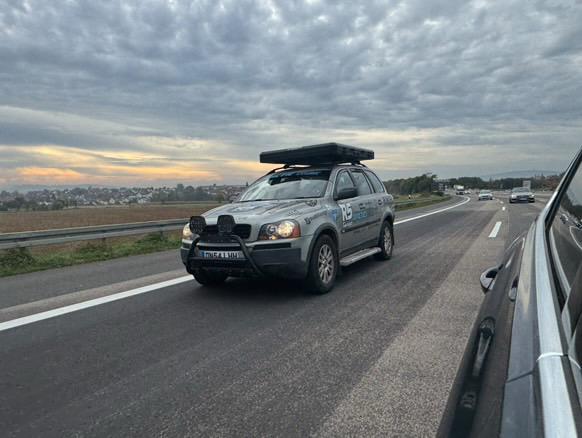 The XC90 with roof tent at speed on a motorway at dusk